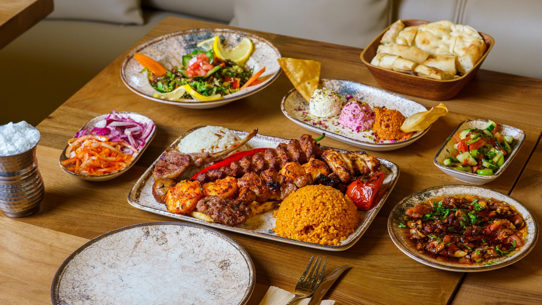 A table set with grilled specialities, meze, bread and salads