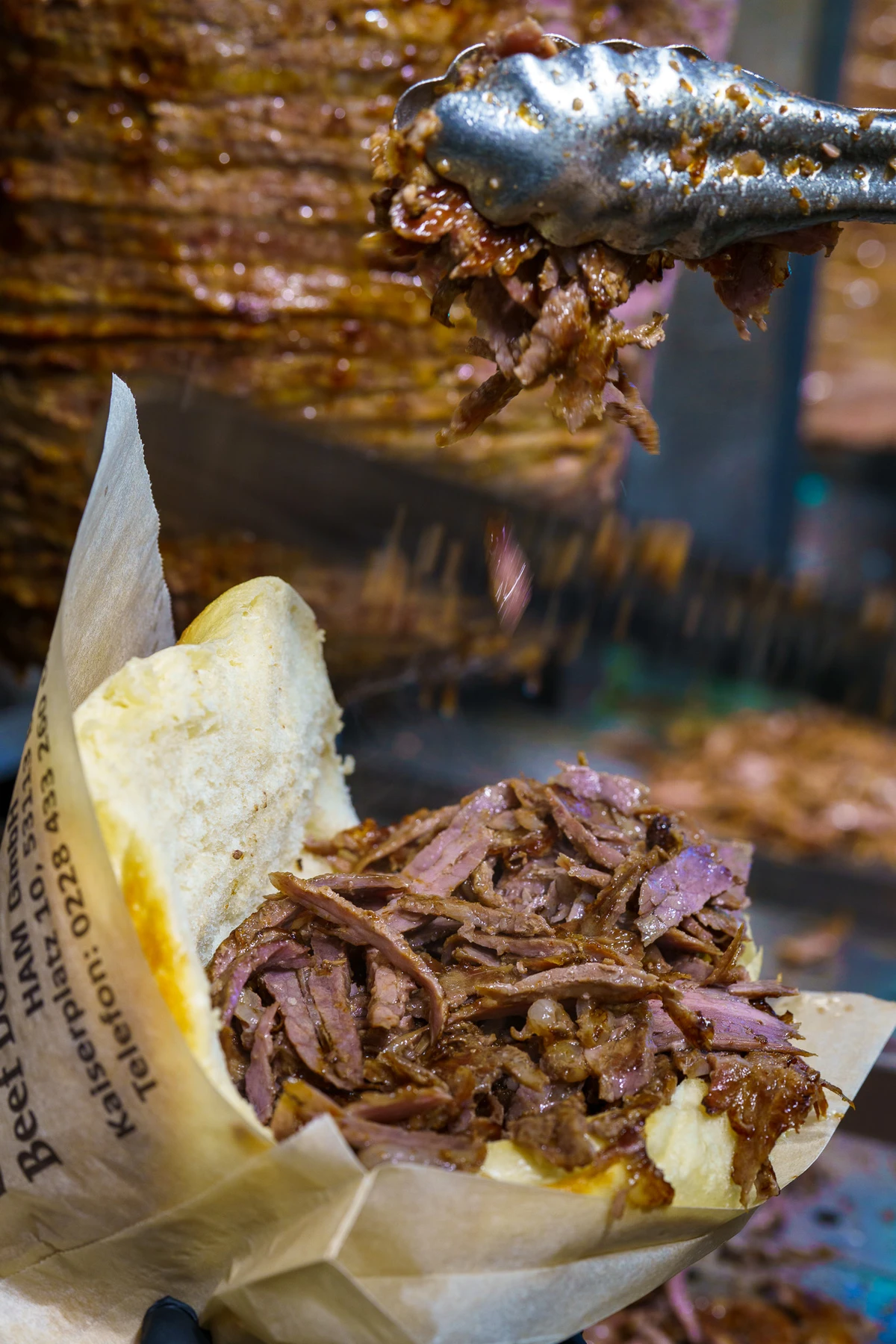 A freshly filled beef döner held in one hand