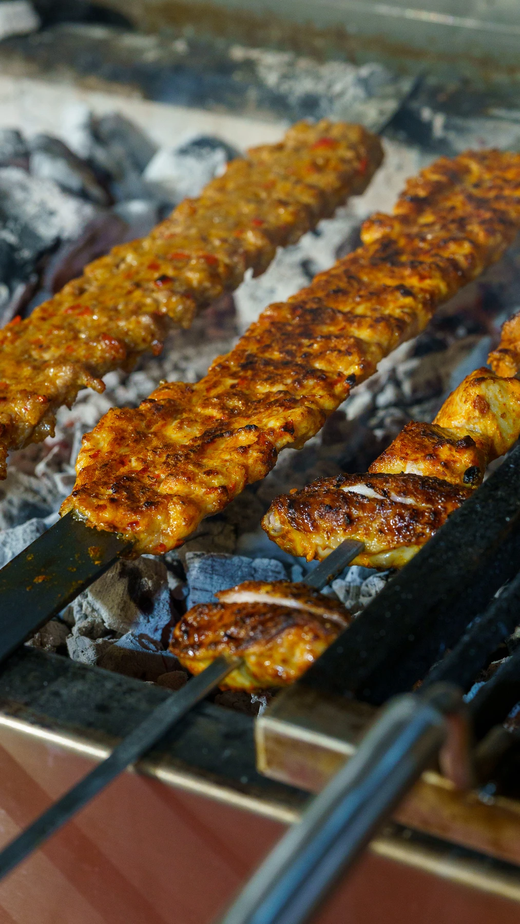 Adana skewers over glowing charcoal